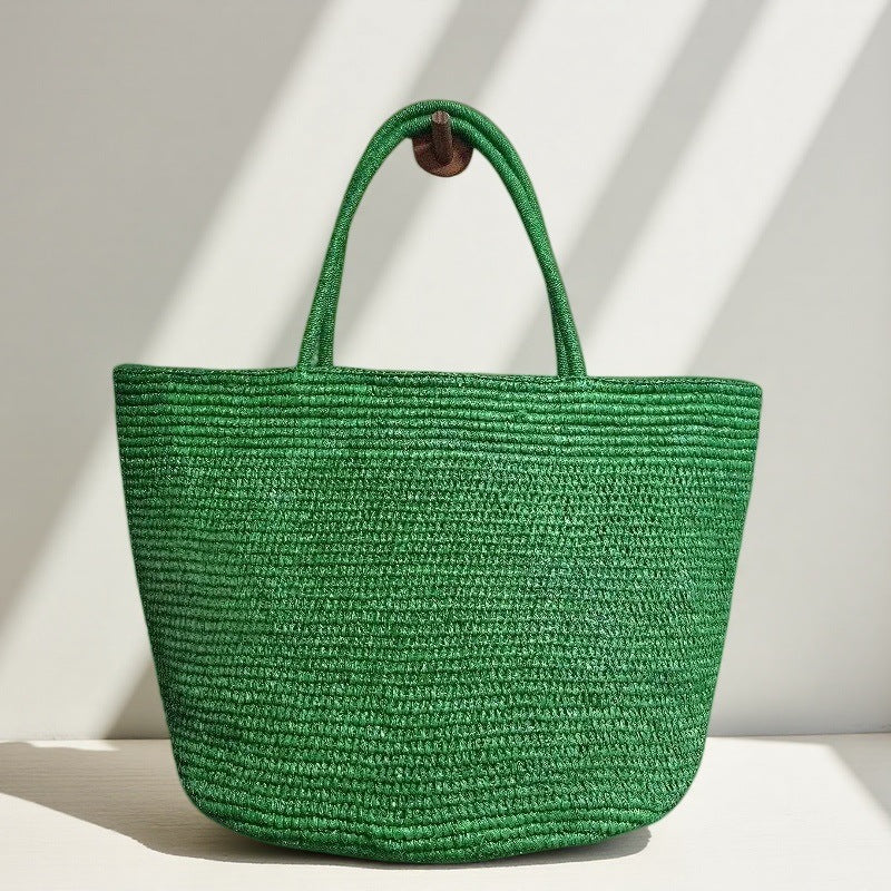 Handwoven raffia tote bag worn on shoulder – lightweight natural straw beach and market bag