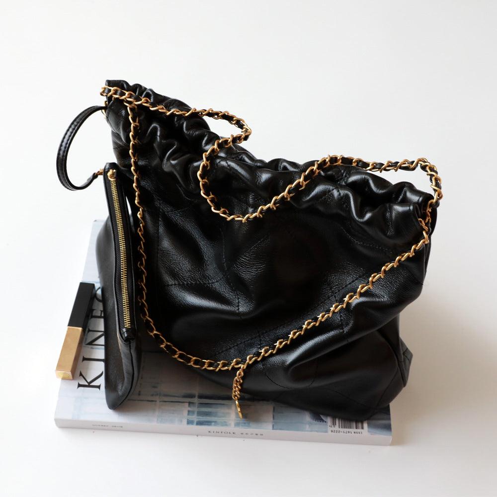 Black calfskin leather shoulder bag with gold-tone chain strap on white background