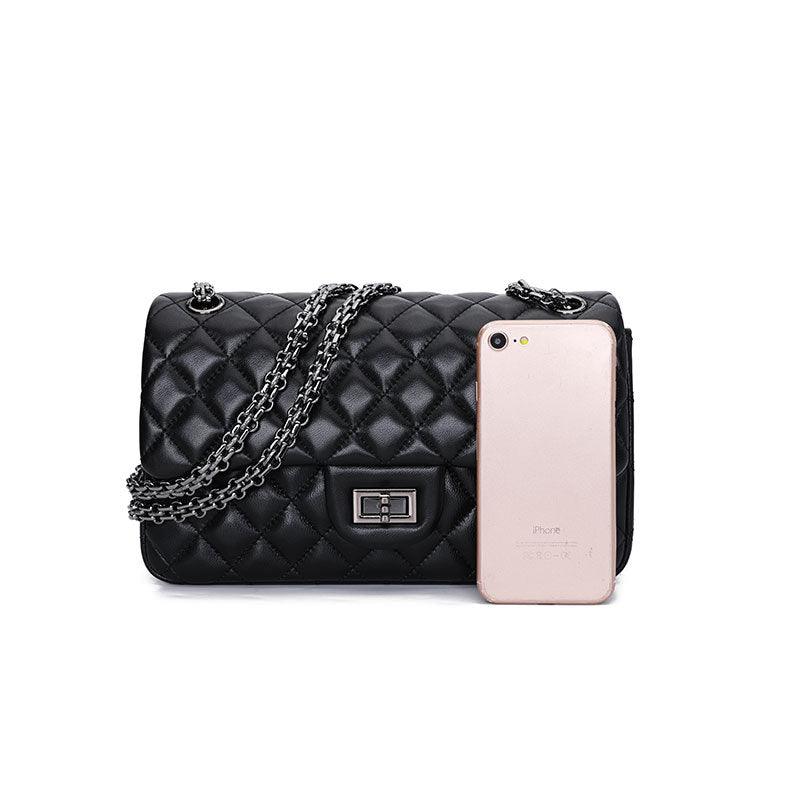 Black quilted genuine leather shoulder bag with chain strap and phone for size reference