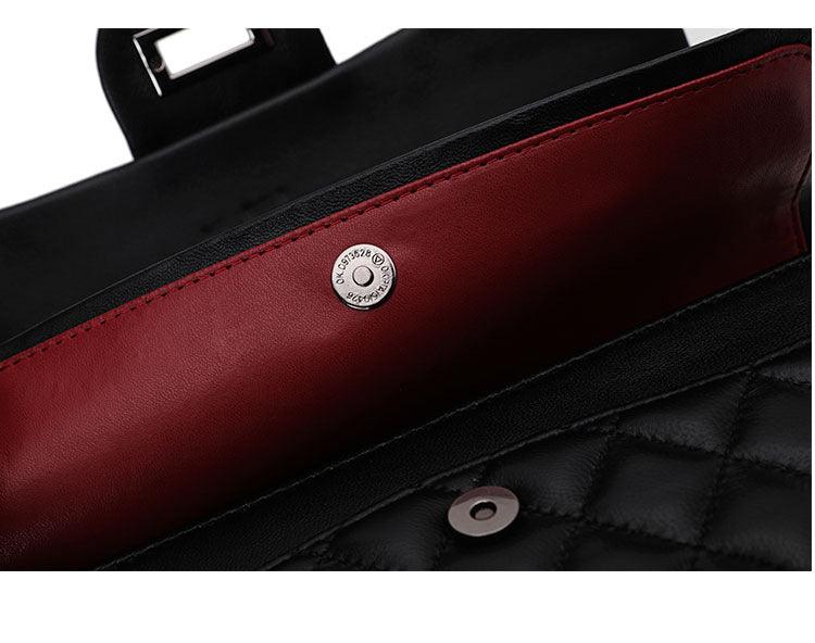 Close-up of quilted black leather shoulder bag with red leather interior and magnetic clasp