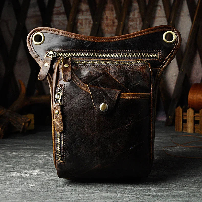 Full grain dark brown leather leg bag with zipper pockets and metal rivet details