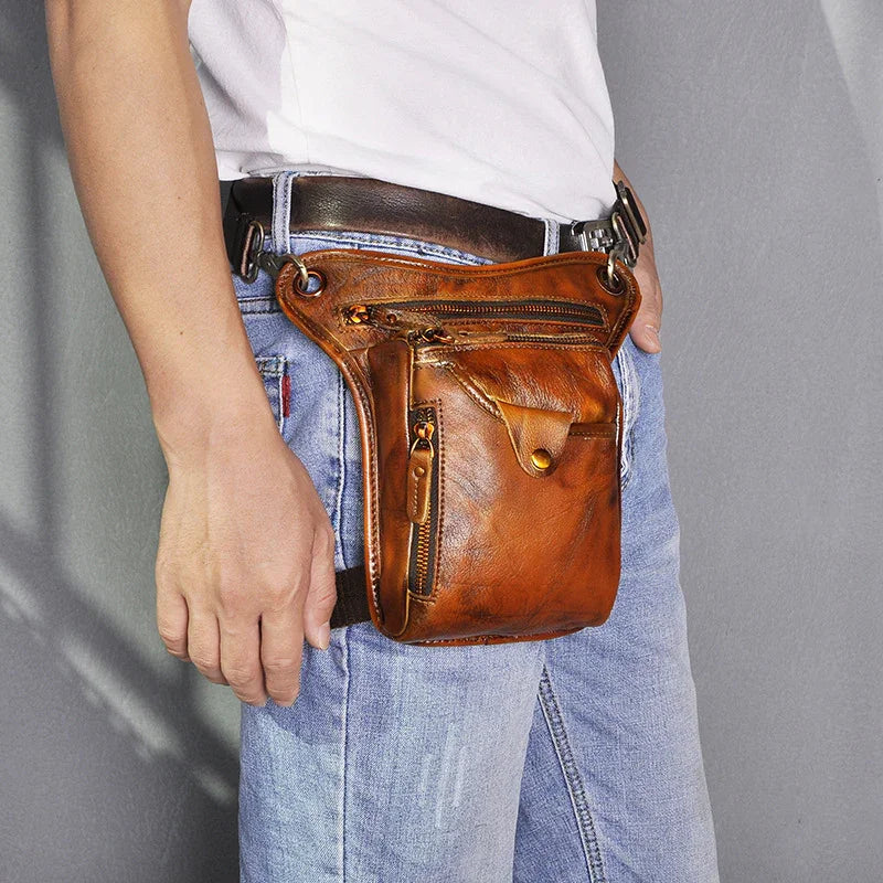 Brown full grain leather leg bag with zippers, worn on belt over jeans
