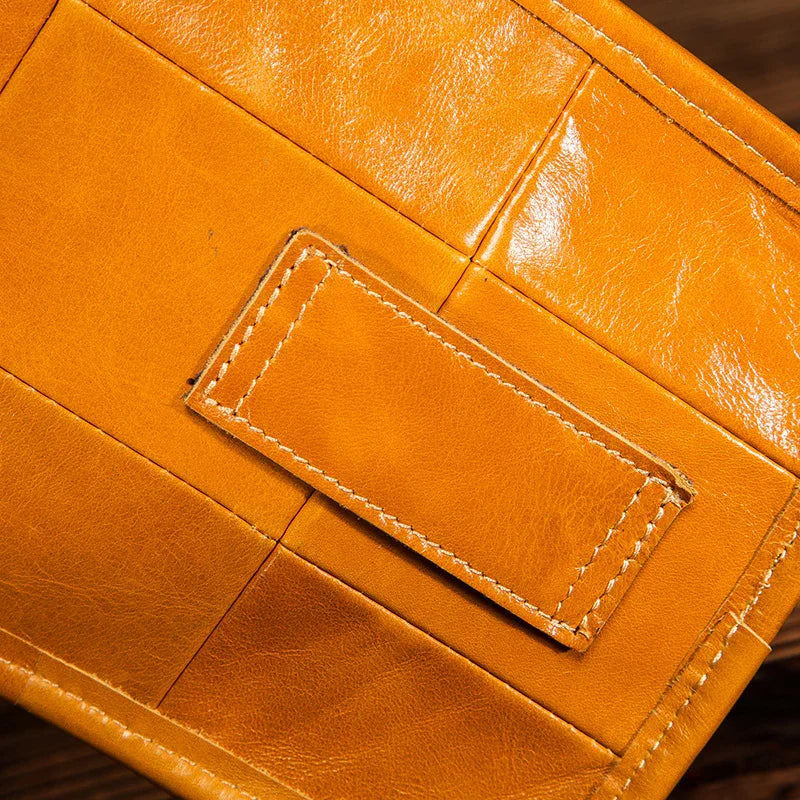 Close-up of tan full grain leather leg bag with detailed stitching and woven pattern.