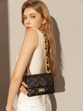 Woman posing with a black quilted leather shoulder bag featuring a gold chain strap