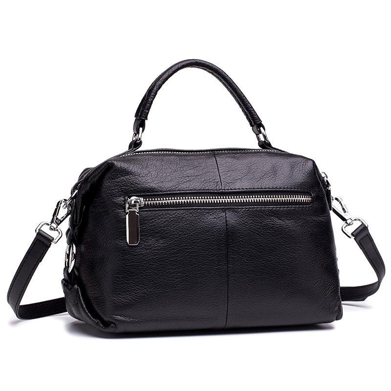 Black genuine leather handbag with top handle, detachable shoulder strap, and front zipper pocket