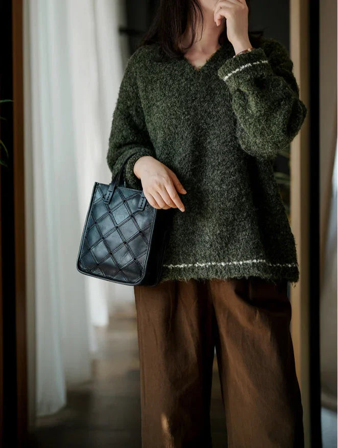 Woman holding black handcrafted cowhide leather handbag with quilted pattern