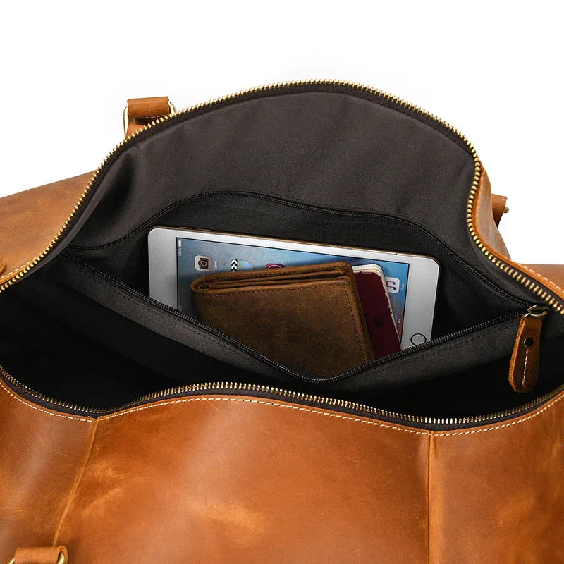 Interior of brown full grain leather duffle bag with tablet, wallet, and phone inside