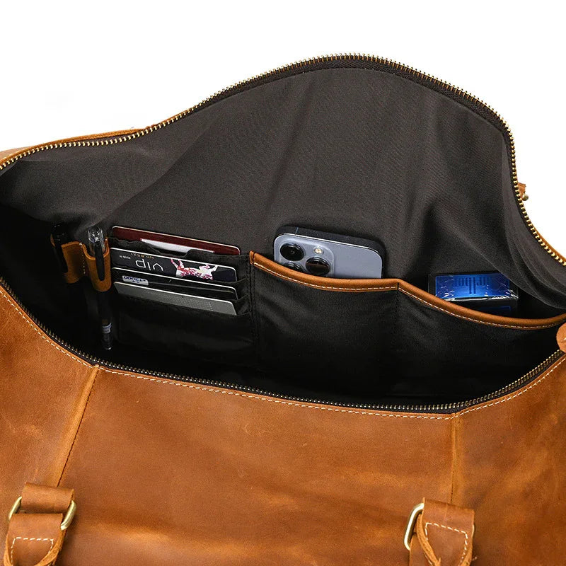 Interior of brown leather duffle bag with organized pockets for cards, phone, and accessories