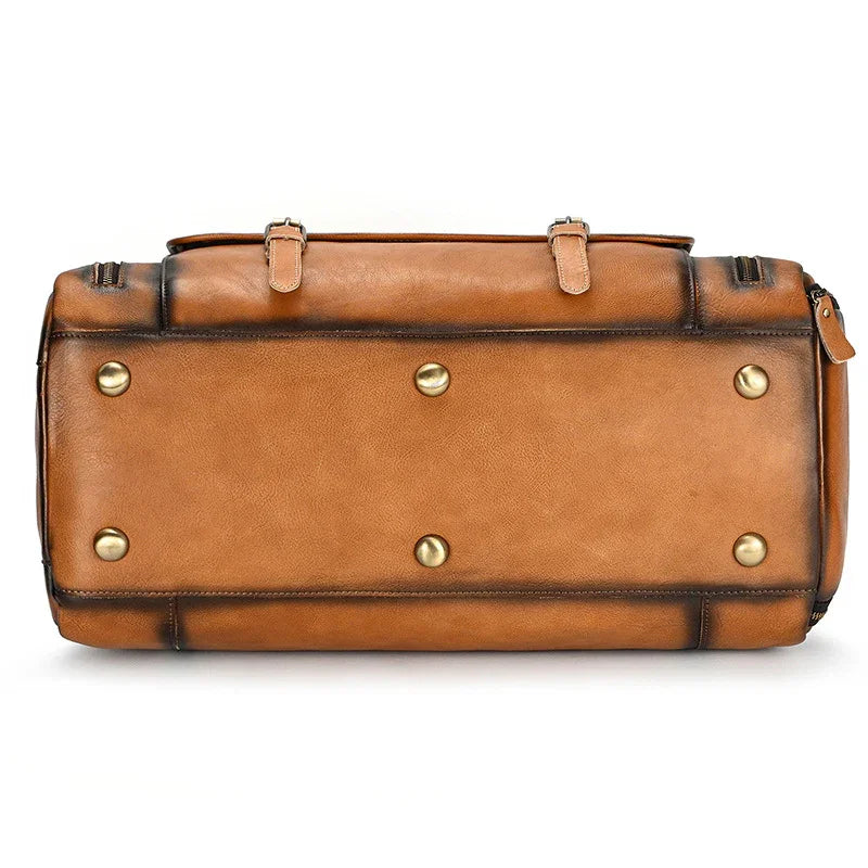 Bottom view of a large handmade full grain leather duffle bag with metal feet and shoe compartment, dark brown.