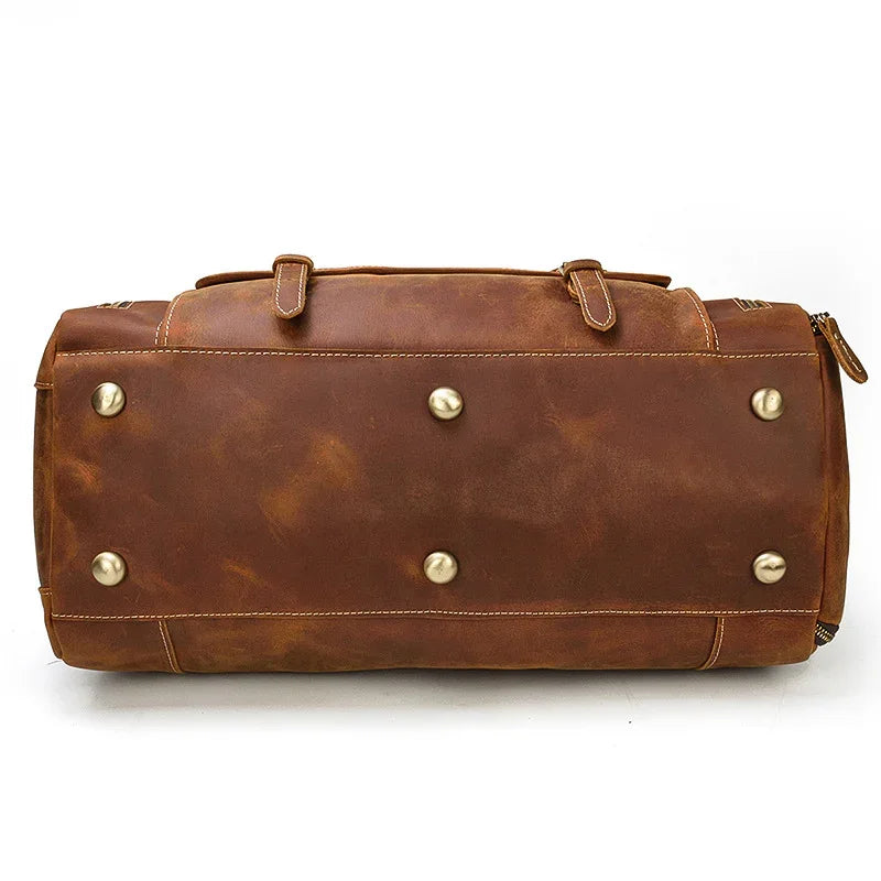 Bottom view of large dark brown full grain leather duffle bag with metal feet and handles