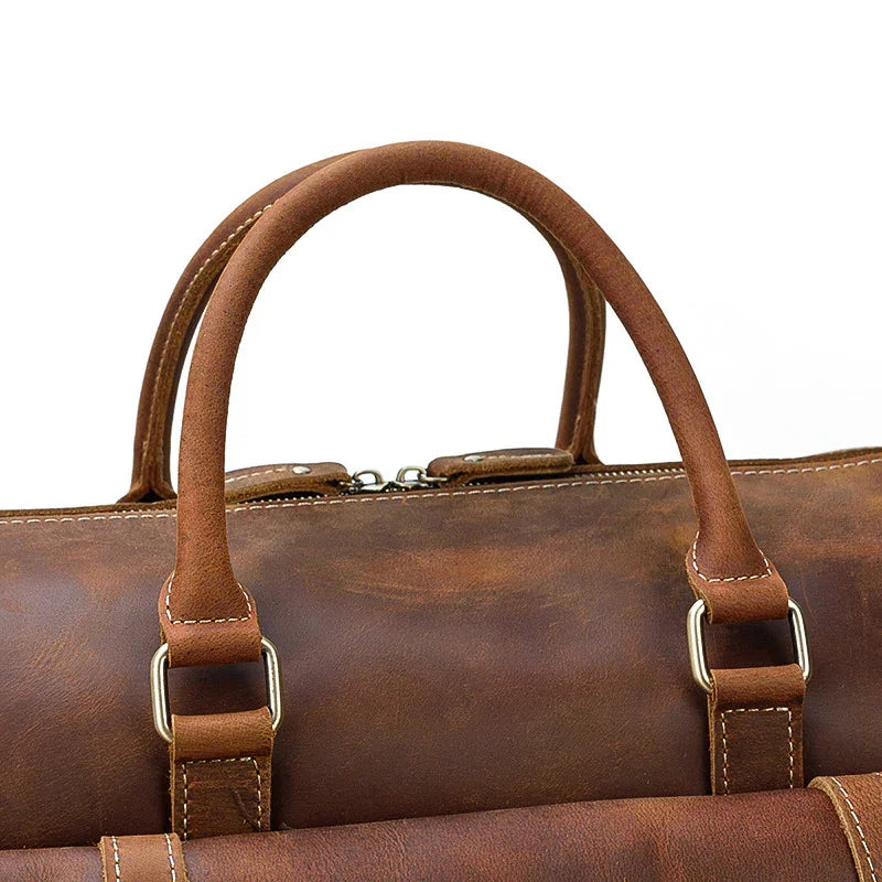 Handmade full grain leather duffle bag in dark brown with sturdy handles and visible stitching
