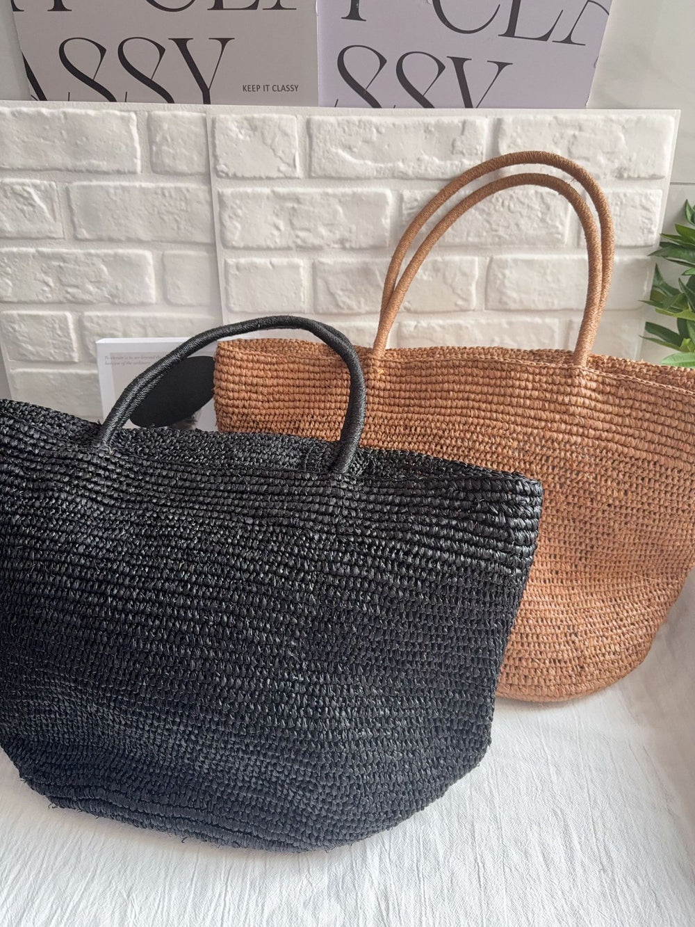 Natural raffia straw tote bag angled view – large handwoven beach vacation bag with woven handles
