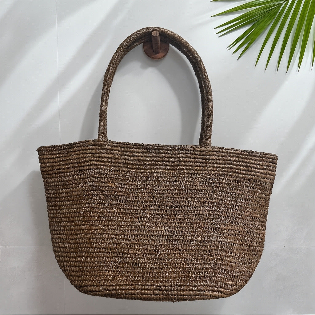 Natural handwoven raffia straw tote bag close-up – fine weave texture artisan beach bag