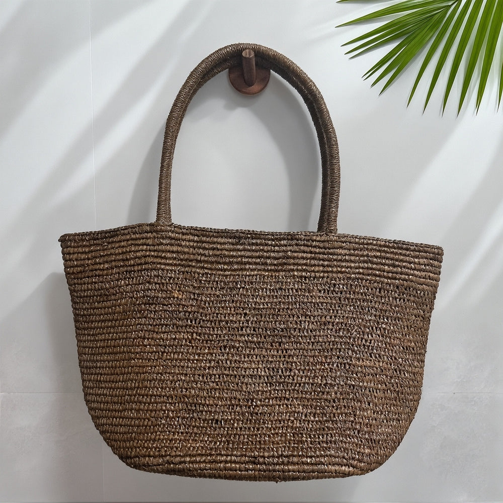 Natural handwoven raffia straw tote bag close-up – fine weave texture artisan beach bag