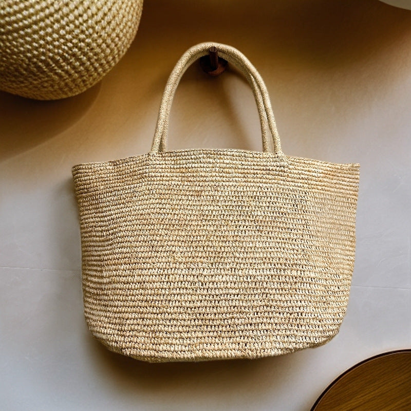 Handwoven raffia tote bag side view – structured woven straw tote with reinforced woven handles