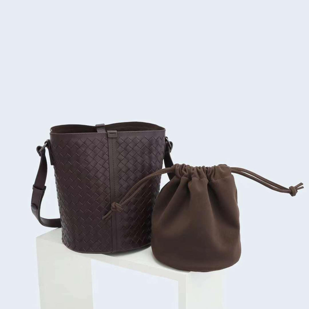 Dark brown woven leather bucket bag with adjustable strap and matching drawstring pouch