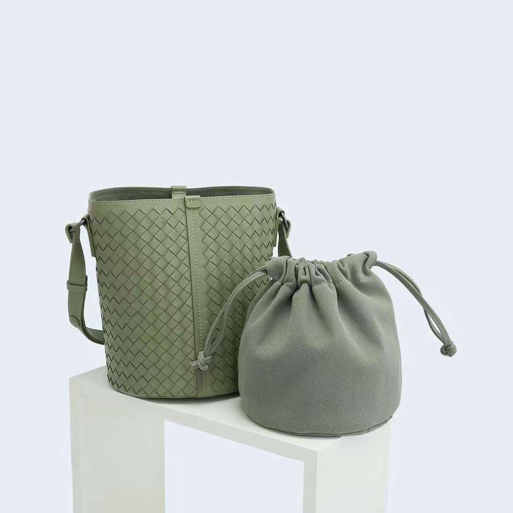 Green interwoven lambskin leather bucket bag with matching drawstring pouch on white display