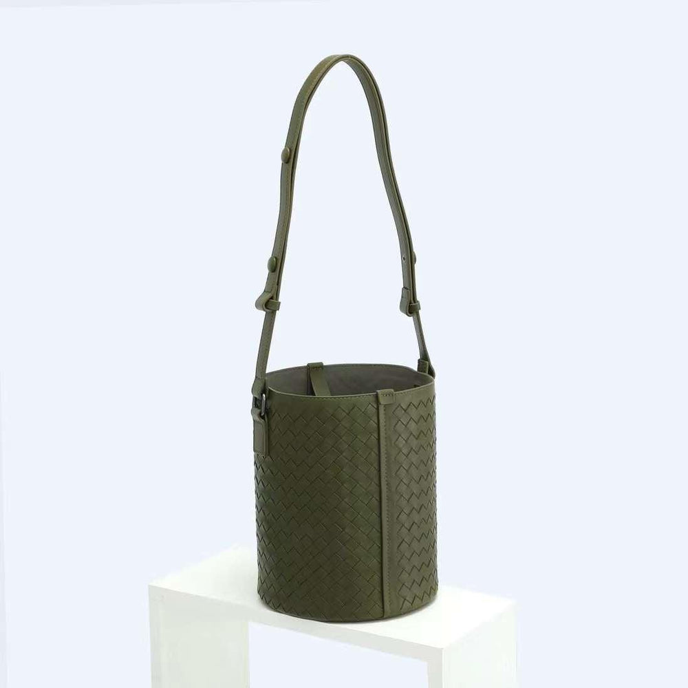 Olive green woven lambskin leather bucket bag with adjustable shoulder strap on white display
