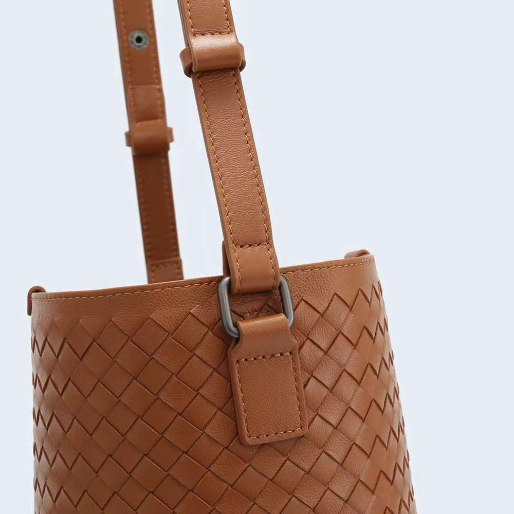 Brown woven lambskin leather bucket bag with adjustable shoulder strap and metal hardware.