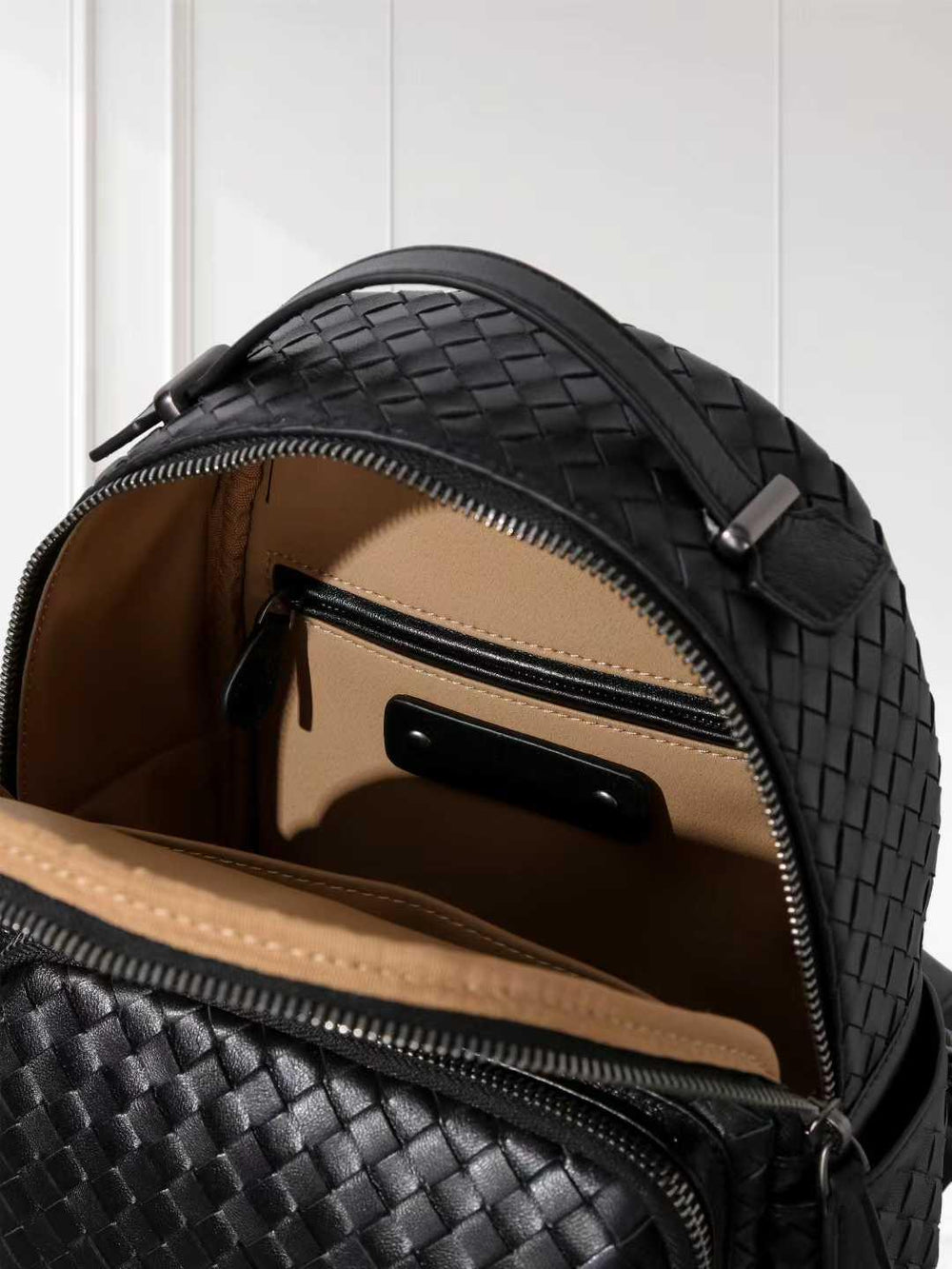 Black woven lambskin leather small backpack with tan interior and zipper pocket