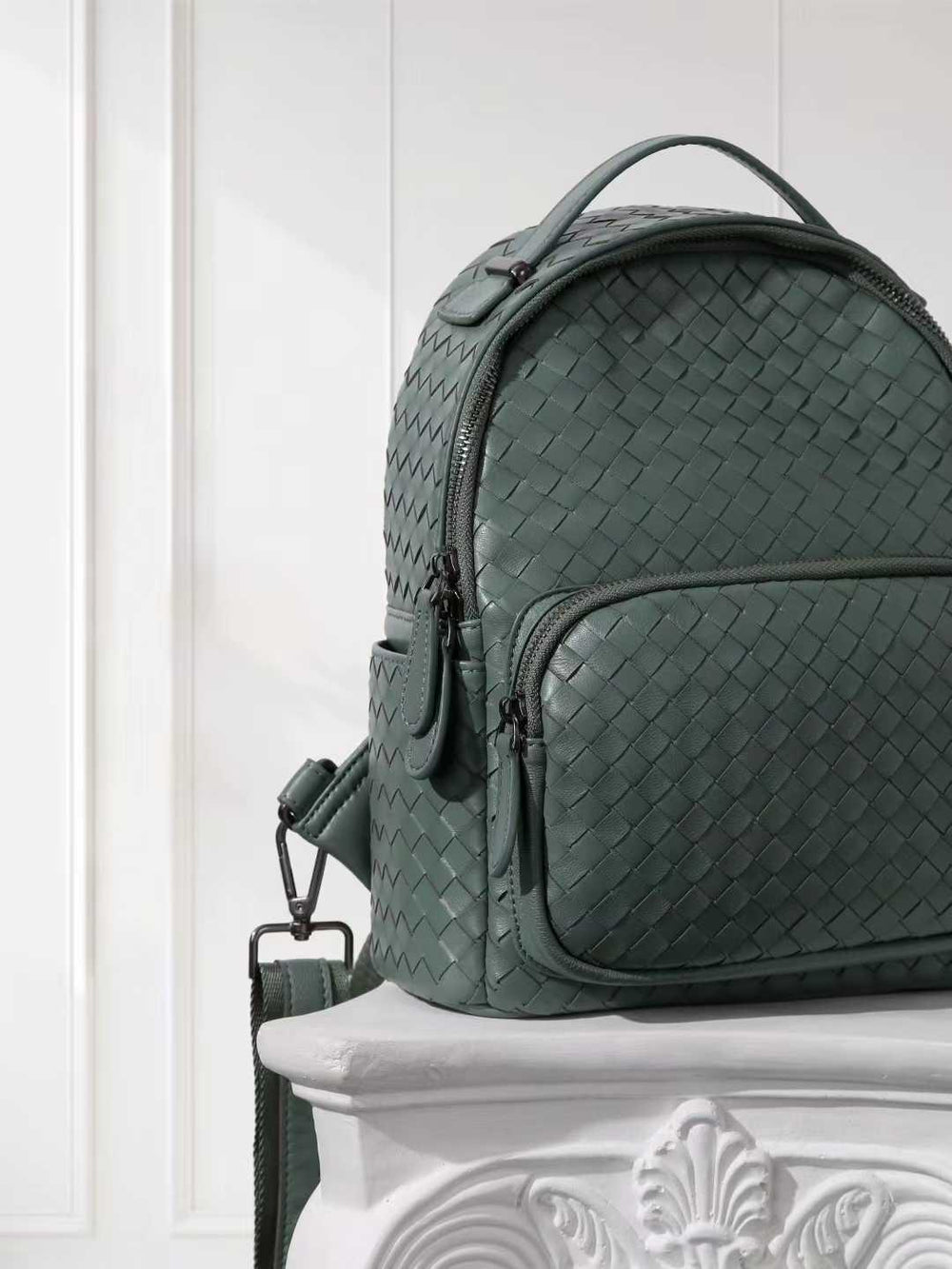 Small green handwoven lambskin leather backpack with front zipper pocket and adjustable strap