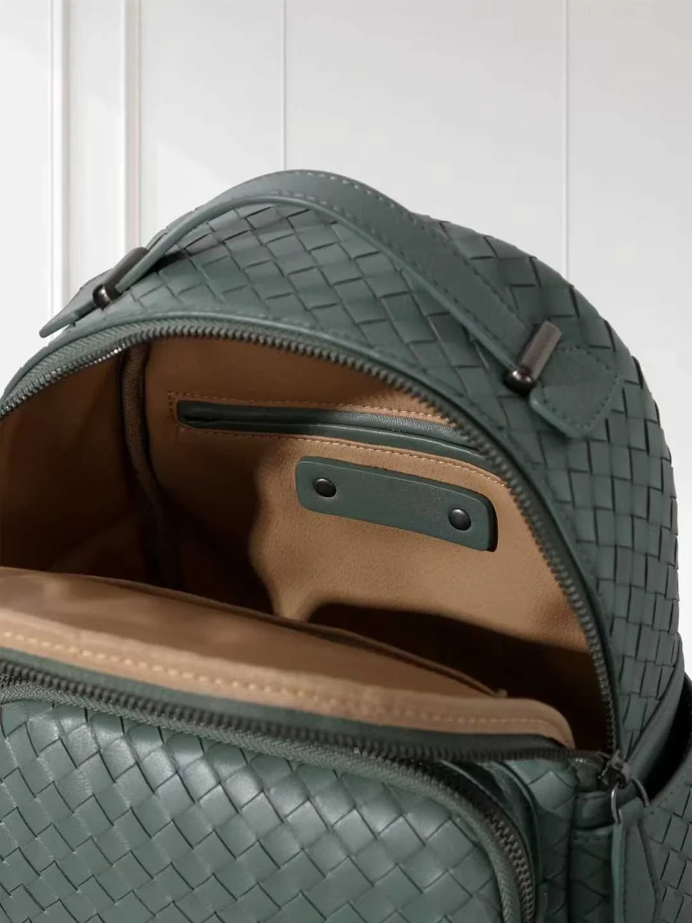 Close-up of hand-woven lambskin leather backpack with quilted texture and tan interior