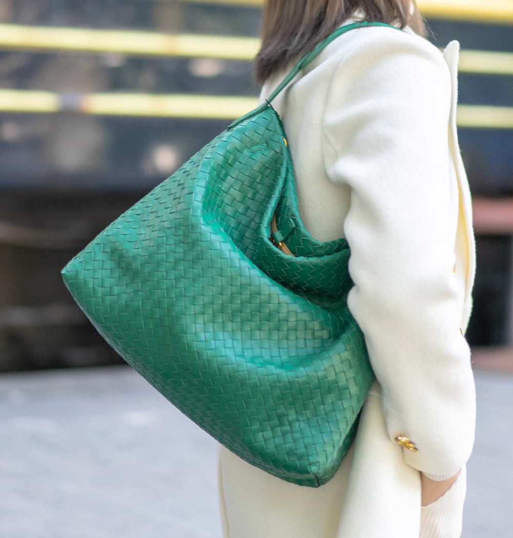 Woman carrying large green woven lambskin leather tote bag on shoulder