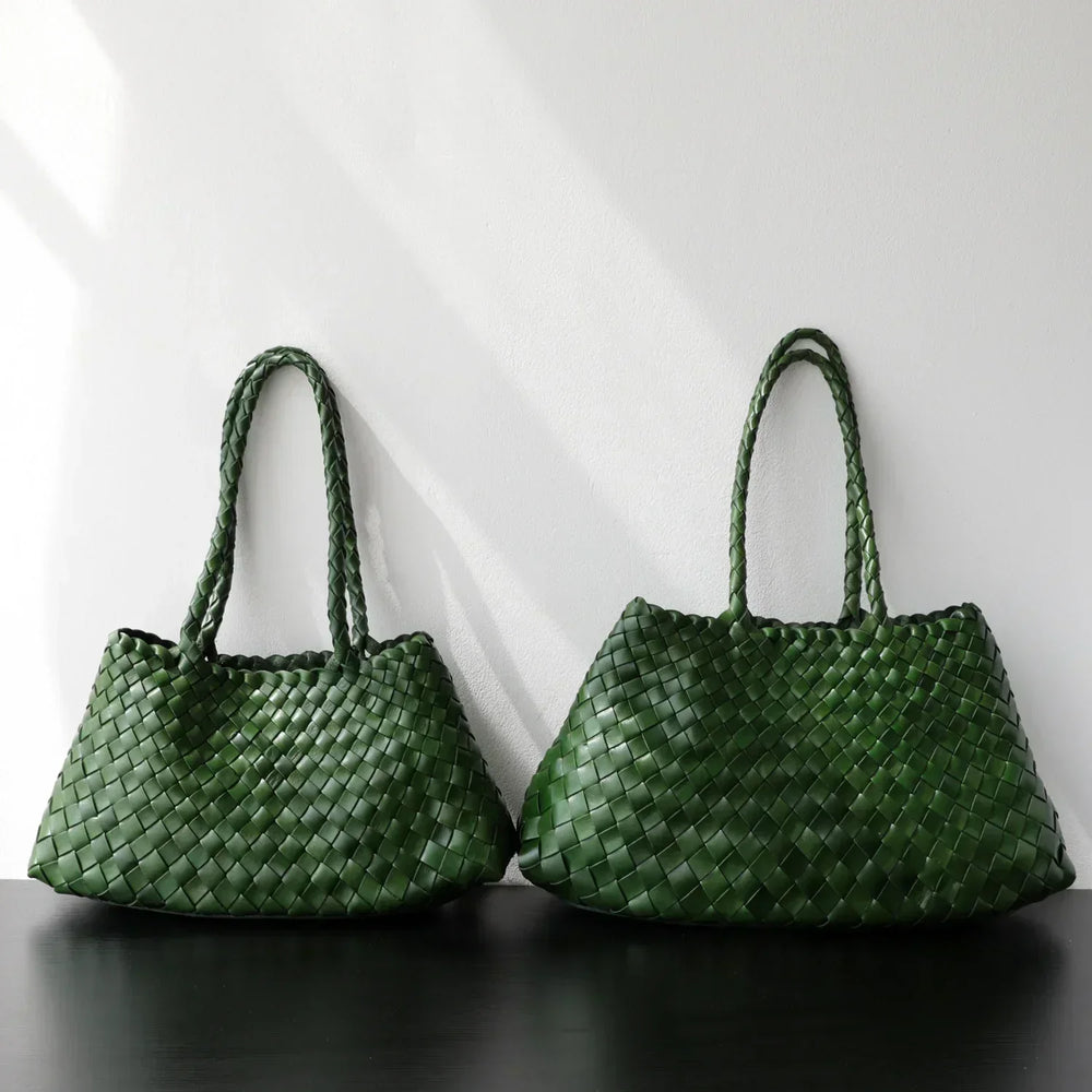 Green woven leather hobo shoulder bags with long handles on black surface, minimalist style