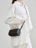 Minimalist black lambskin leather box bag with adjustable strap worn crossbody