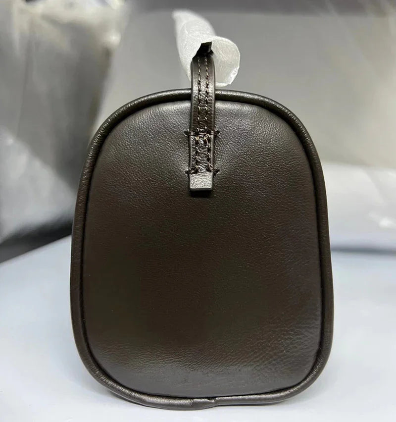 Side view of a minimalist dark brown lambskin leather box bag with smooth texture