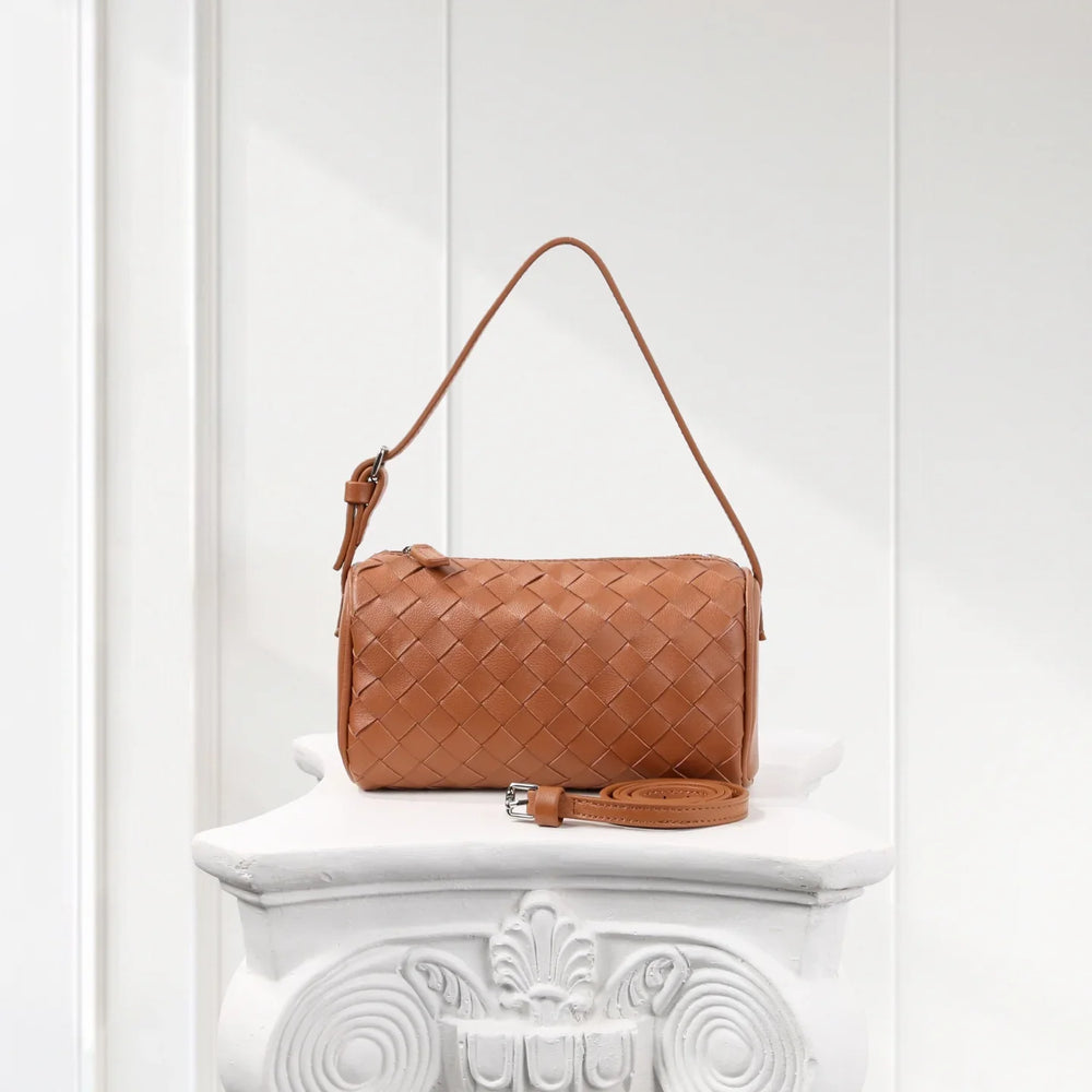 Tan lambskin leather woven mini Boston bag with detachable strap on a white pedestal