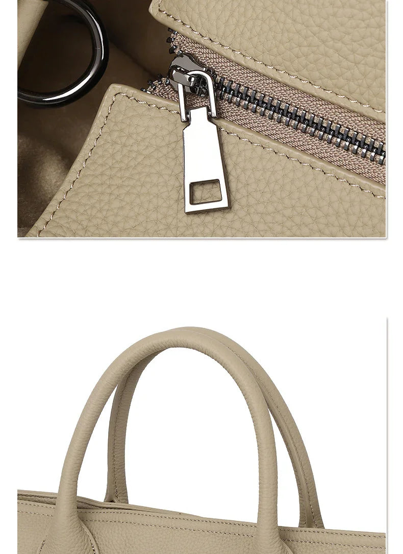 Close-up of beige cowhide leather tote bag with textured finish, silver zipper, and sturdy handles.