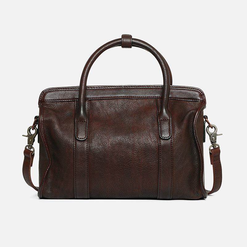 Brown leather Boston bag with top handles and detachable shoulder strap on white background