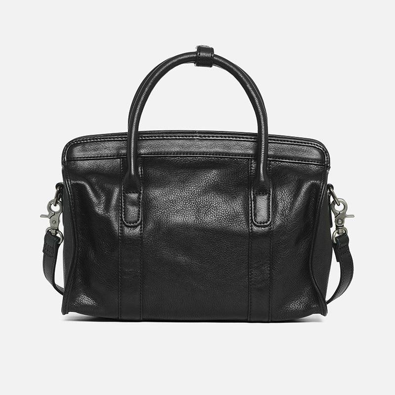 Black leather Boston bag with top handles and detachable shoulder strap on white background