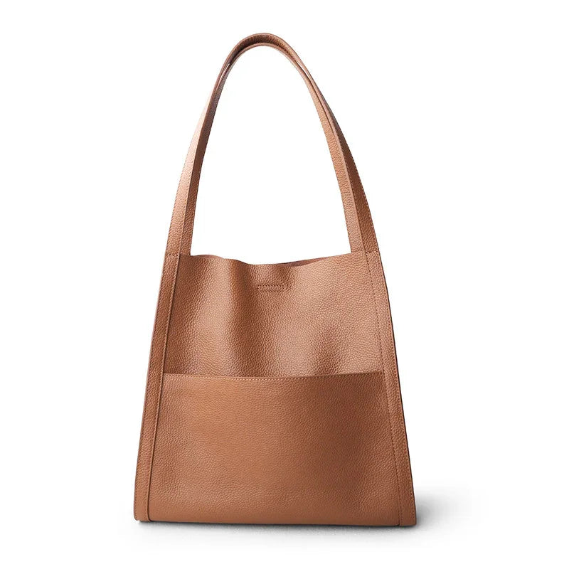 Minimalist brown grain cowhide leather tote bag with long shoulder handles on white background