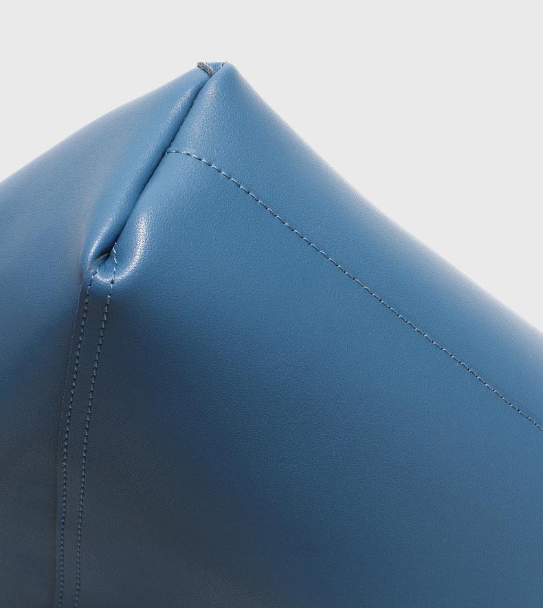 Close-up of blue genuine leather handbag corner with visible stitching detail