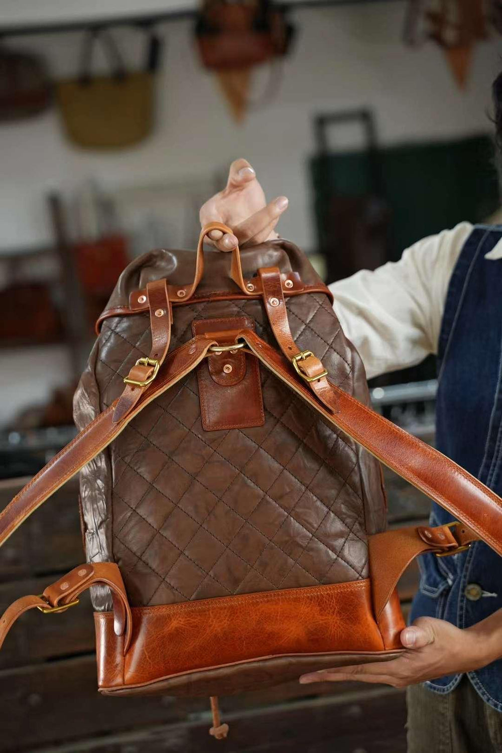 Brown full grain cowhide leather backpack with quilted pattern, adjustable straps, and brass buckles