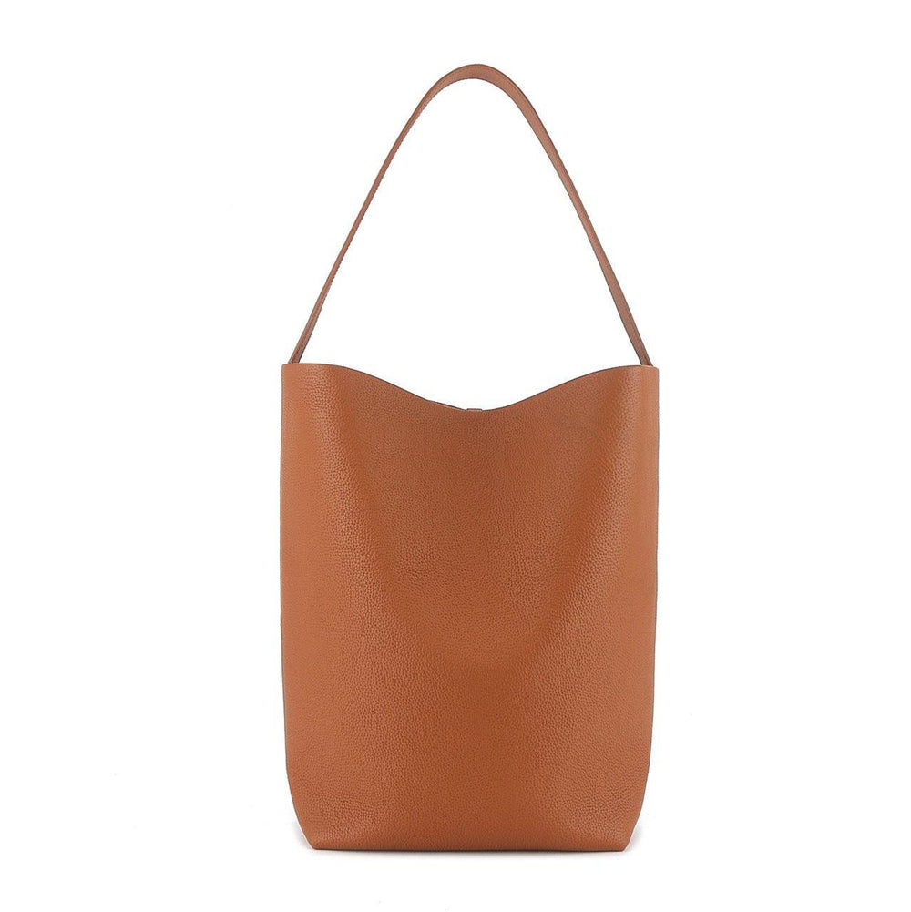 Minimalist tan leather bucket bag with single shoulder strap on white background