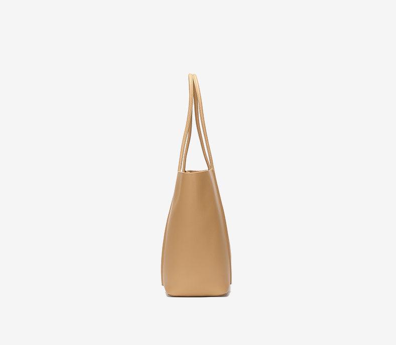 Side view of a minimalist beige genuine leather tote bag with double top handles