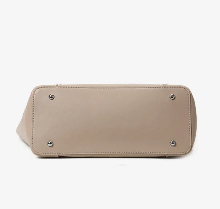 Beige genuine leather tote bag with metal feet, minimalist design, bottom view