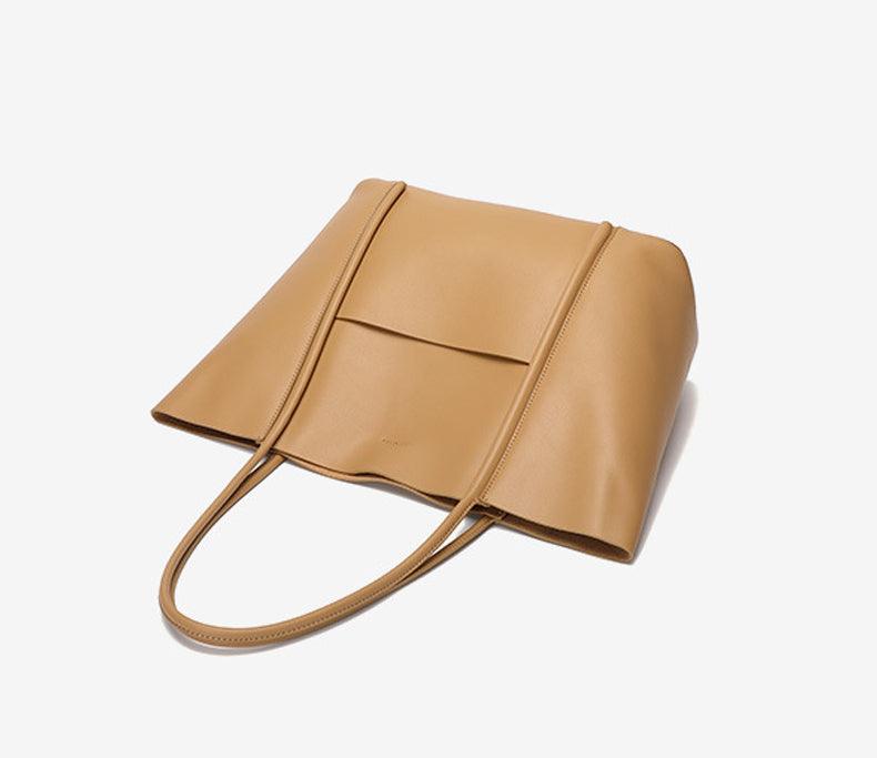 Minimalist genuine leather tote handbag in beige with top handles on white background