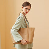 Woman in mint blazer carrying beige minimalist genuine leather tote handbag