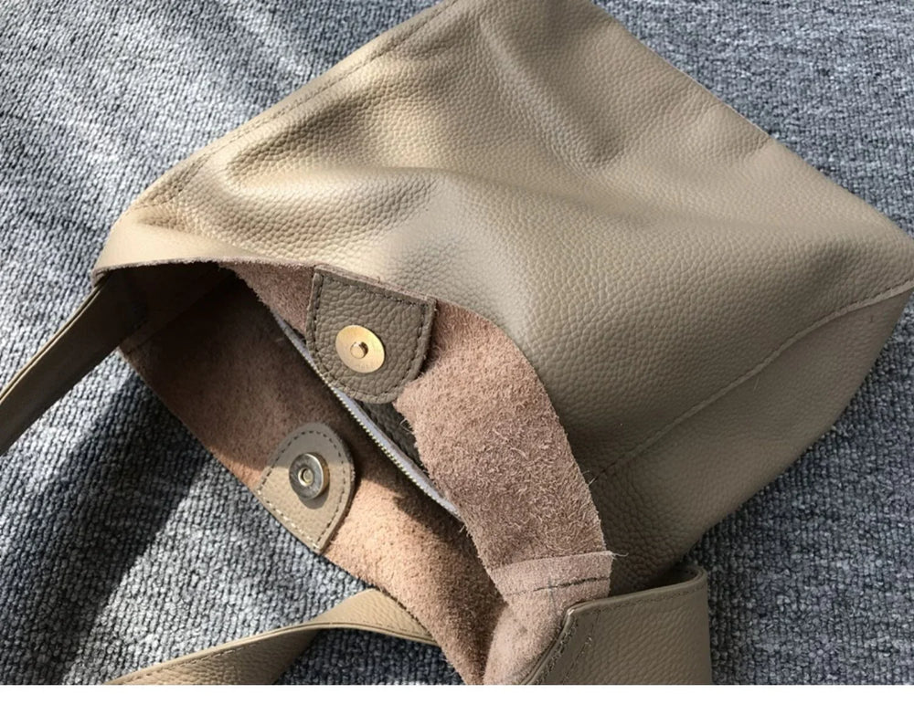 Minimalist pebbled cowhide leather bucket bag with wide shoulder strap and magnetic closure