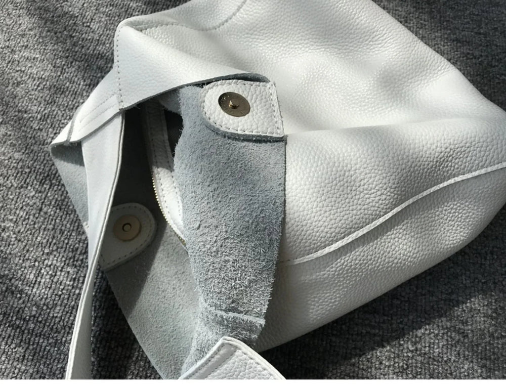 Minimalist white pebbled cowhide leather bucket bag with wide strap and magnetic closure