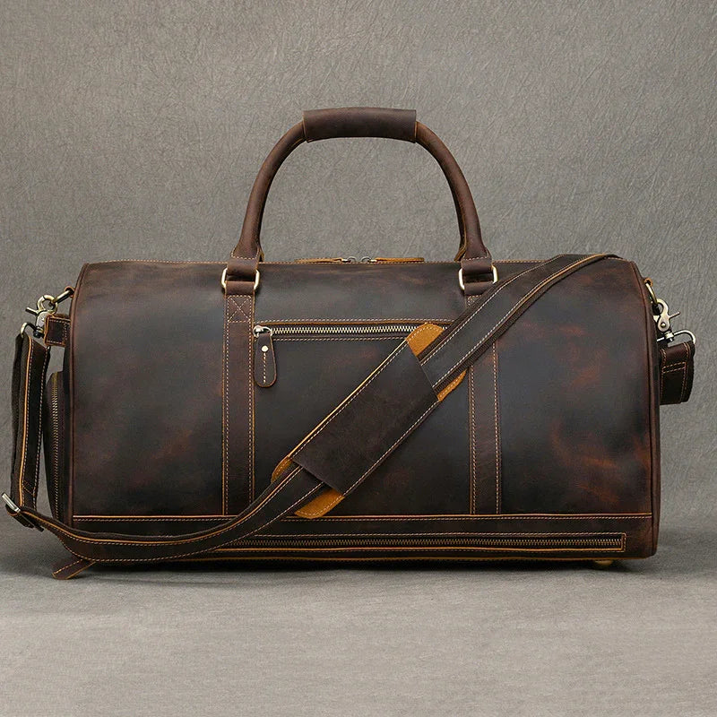 Dark brown leather duffle bag with shoulder strap, front zipper pocket and sturdy handles.