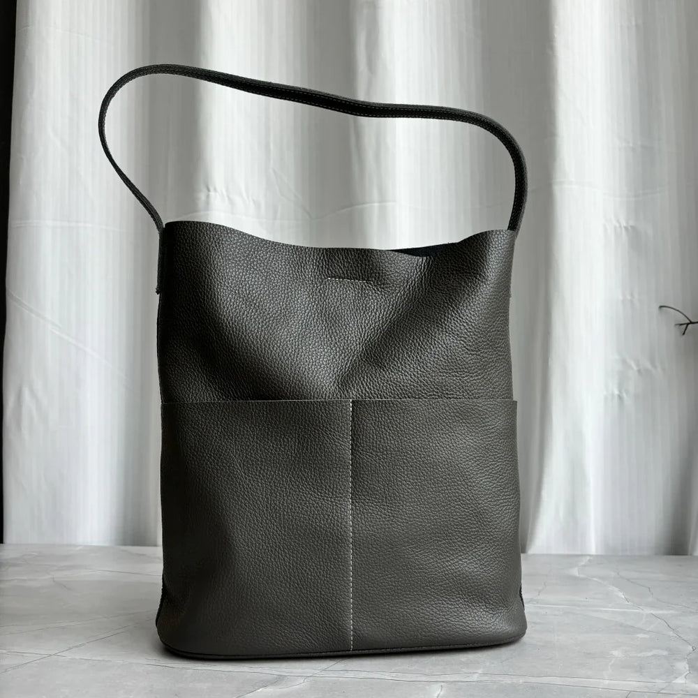 Soft dark brown cowhide leather tote bag with two front pockets and a single shoulder strap, displayed upright.
