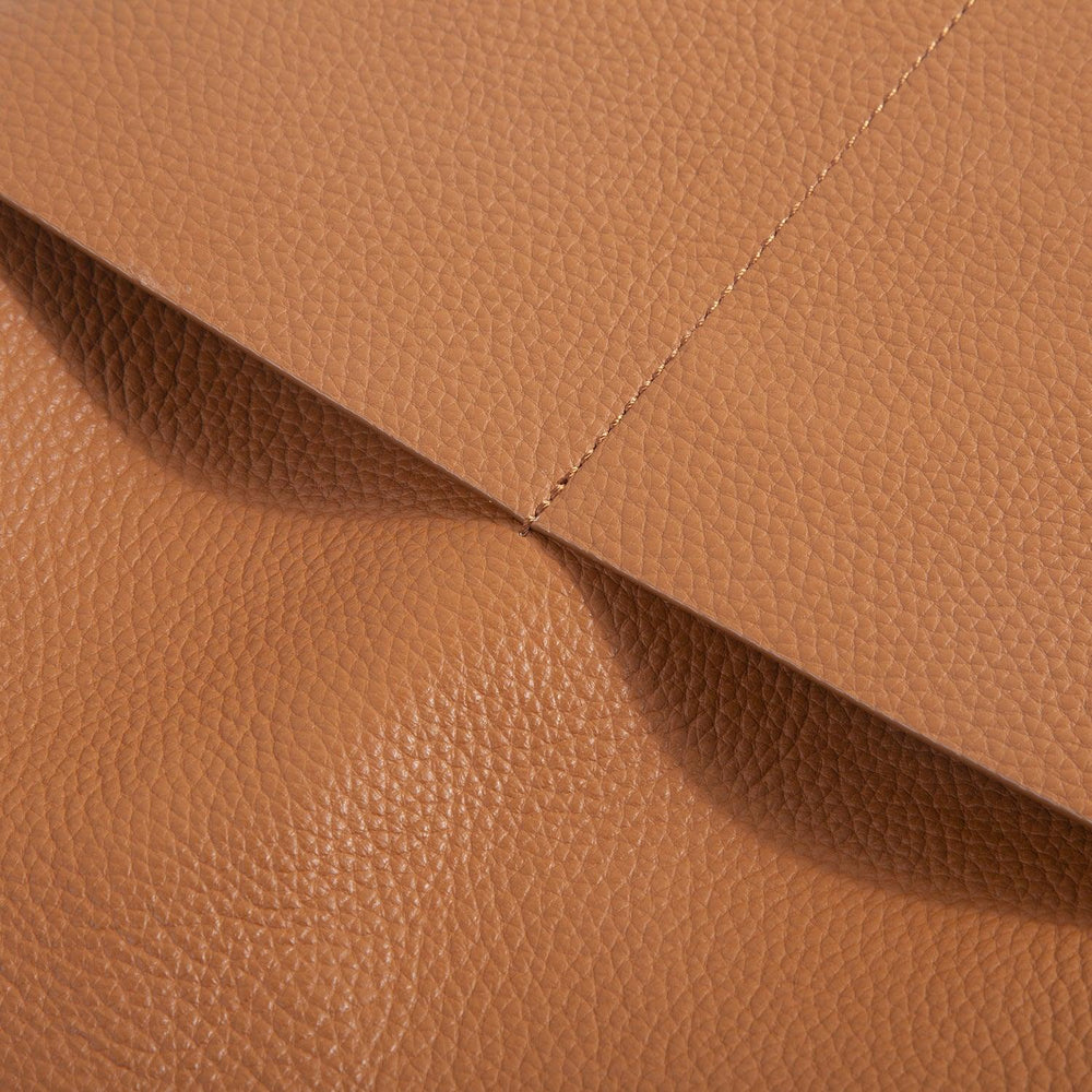 Closeup of soft tan cowhide leather with detailed stitching on a tote bag pocket