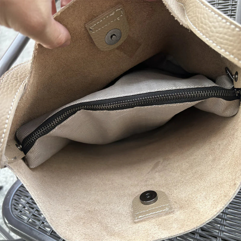 Interior of beige cowhide leather tote bag with suede lining and zippered pocket