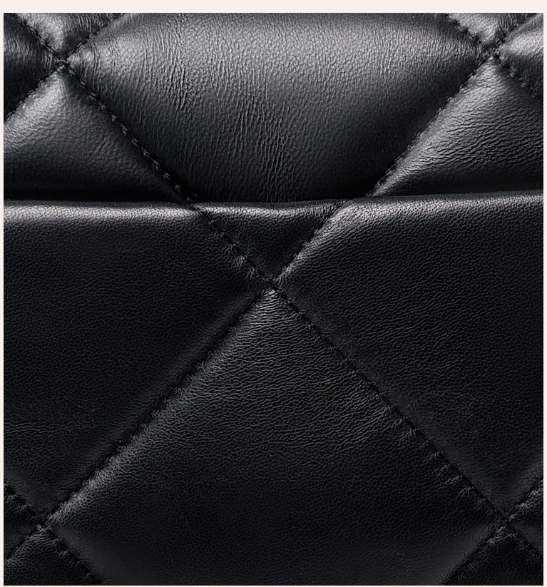 Close-up of black quilted genuine leather with diamond stitching, luxury bag texture