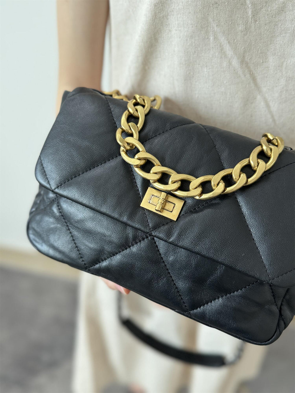 Black quilted leather shoulder bag with gold chain strap and turn-lock closure